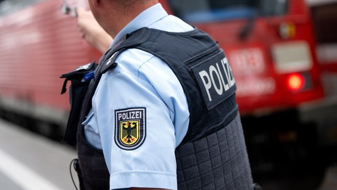 Ein Bundespolizist steht an einem Bahnsteig vor einem Zug - nach der tödlichen Attacke auf einen Zugbegleiter hat die Gewerkschaft EVG zu einem Pressegespräch zum Thema Sicherheit geladen.