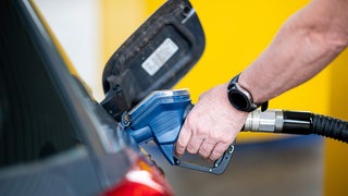 Eine Person beim Betanken eines Autos.
