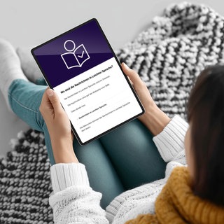 Eine Frau liest die Nachrichten in Leichter Sprache auf ihrem Tablet.