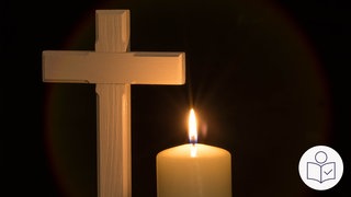 Ein Kreuz aus Holz. Daneben eine brennende Kerze vor einem dunklen Hintergrund. Rechts das SWR Logo für Leichte Sprache. Warum ist Kar·freitag ein stiller Feier·tag?