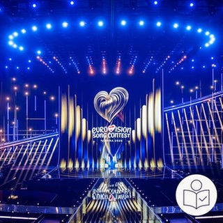 Die Bühne von dem ESC 2026 in Wien. Viele Lichter leuchten auf die Bühne. Rechts das SWR Logo für Leichte Sprache.