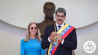 Der Präsident von Venezuela steht neben seiner Frau. Die USA haben den Präsidenten von Venezuela gefangen genommen. Rechts das SWR Logo für Leichte Sprache.
