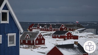 Mehrere rote und blaue Holz·häuser im Schnee. Die Holz·häuser sind in Grönland. Rechts SWR-Logo für Leichte Sprache.