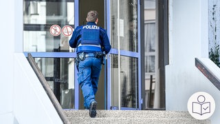 Ein Polizist von hinten. Er geht Treppen hoch und durch eine blaue Tür. Die Tür ist der Eingang von einer Schule in Ludwigshafen. Rechts das SWR Logo für Leichte Sprache.