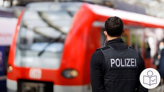 Das ist ein Beispiel-Bild: Ein Polizist steht vor einem Regional·zug. Man sieht den Polizist von hinten. Er hat eine Schutz·weste mit dem Wort Polizei an. Rechts das SWR Logo für Leichte Sprache. 