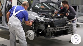 Zwei Arbeiter in einem Auto·werk. Sie arbeiten an einem Auto. Die Motor·haube von dem Auto ist geöffnet. Rechts das SWR Logo für Leichte Sprache . 