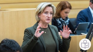 Die Wirtschaftministerin von Baden-Württemberg Nicole Hofmeister-Kraut hält eine Rede im Landtag. Männer hören Frauen im Landtag nicht so gut zu. Das zeigt eine Studie. Rechts das SWR Logo für Leichte Sprache. 