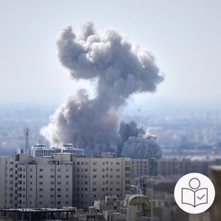 Auf dem Bild sind Hoch·häuser zu sehen. Aus ihnen steigt weißer Rauch auf. Die Rauchwolke ist sehr groß. Rechts das SWR Logo für Leichte Sprache. 