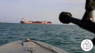 Auf dem Bild ist ein großes Transport·schiff. Eine Waffe zielt auf das Schiff. Rechts das SWR Logo für Leichte Sprache.  