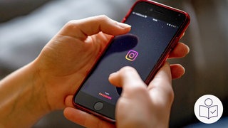 Das ist ein Beispiel·bild: Man sieht zwei Hände. Die Hände halten ein Smart·phone. Darauf zu sehen ist die Instagram-App. Rechts das SWR Logo für Leichte Sprache.   