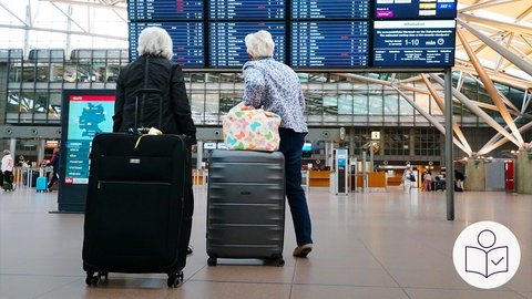 Zwei ältere Frauen stehen am Flughafen. Die Frauen haben Koffer dabei. Die Frauen gucken auf die Anzeige der Abflüge und Landungen. Rechts das SWR Logo für Leichte Sprache. Wegen Streiks bei der Lufthansa fallen viele Flüge aus. 
