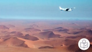 Das ist ein Beispiel·bild. Auf dem Foto ist eine Wüste in Namibia. Rechts oben fliegt ein kleines Flugzeug mit einem Propeller. Rechts unten das SWR Logo für Leichte Sprache.