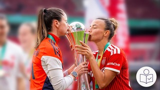 Zwei Fußball-Spielerinnen vom FC Bayern halten einen silbernen Pokal. Die Spielerinnen küssen den Pokal. Die Frauen vom FC-Bayern haben den DFB-Pokal gewonnen. Rechts das SWR Logo für Leichte Sprache.