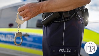 Ein Polizist hält Handschellen in der Hand. Rechts das SWR Logo für Leichte Sprache. 