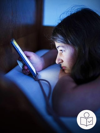 Ein Mädchen liegt im Dunkeln auf ihrem Bett. Sie schaut auf den leuchtenden Bild·schirm von ihrem Handy. Rechts das SWR Logo für Leichte Sprache.