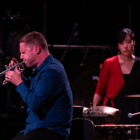 Peter Evans spielt Trompete, im Hintergrund Sae Hashimoto