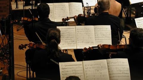 Blick aufs Notenpulte der Streicher mit den Noten des Werks von Chaya Czernowin