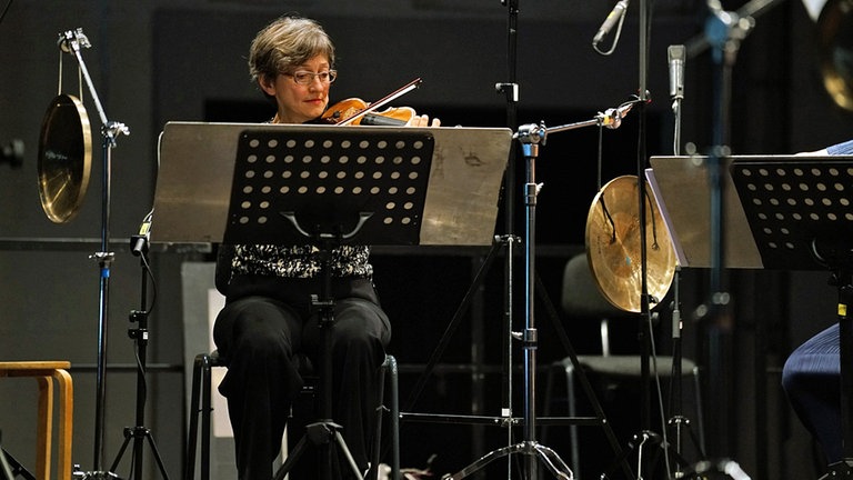 Geigerin spielt ihr Instrument hinter dem Notenpult