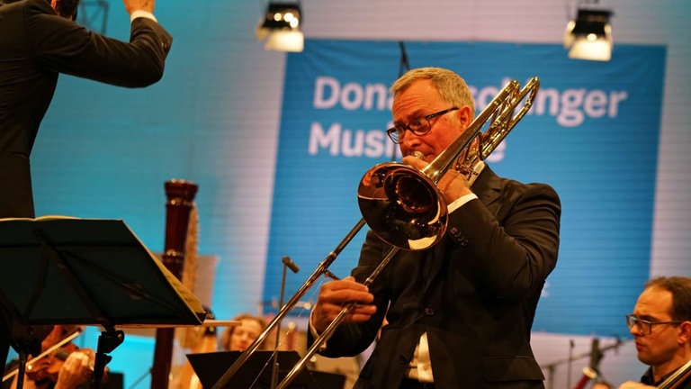 Posaunist spielt mit Orchester