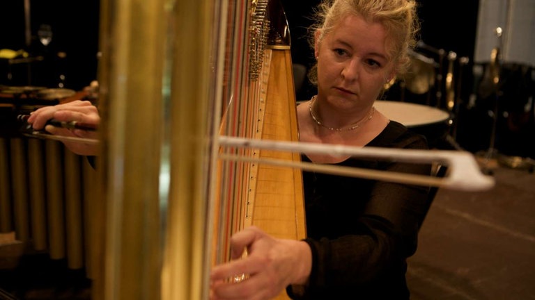 Frau spielt Harfe