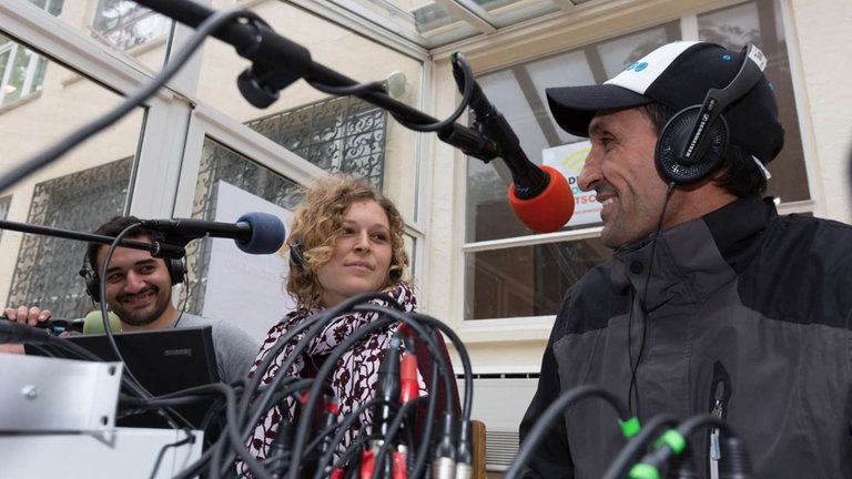 Drei Menschen an Mikrophonen