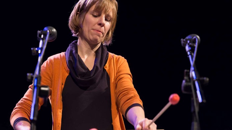 Frau spielt Vibraphon mit roten Schlägeln bei der NOWJazz-Session in der Sporthalle der Gewerbeschulen