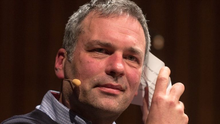 Mann mit Mikroport und Papier