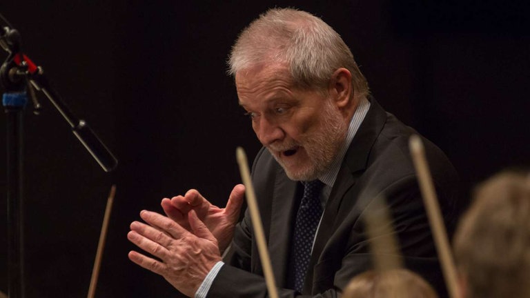 Mann hebt die Augenbrauen beim Dirigieren