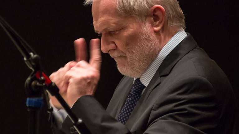 Dirigent mit zwei erhobenen Zeigefingern