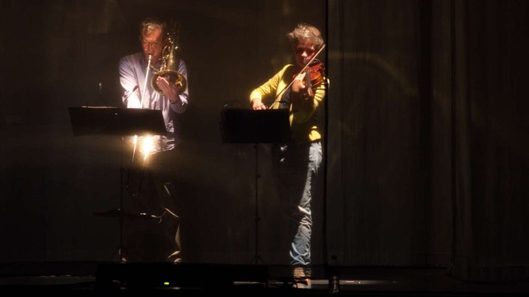 Posaunist und Geigerin vom Nadar Ensemble proben "Mirror Box #2" von Stefan Prins