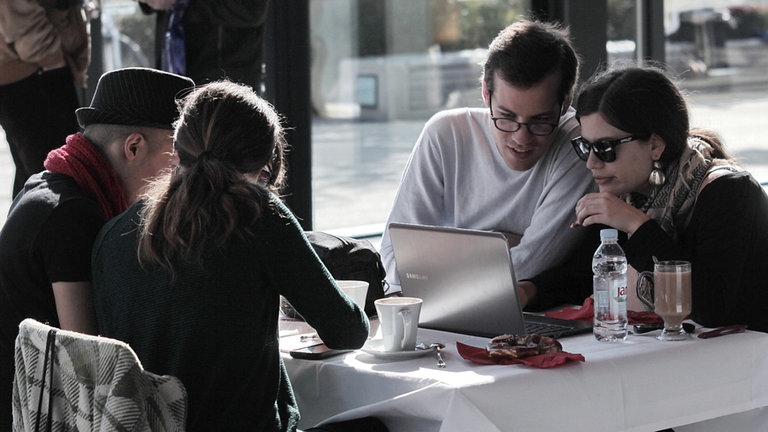 Mann und Frau schauen auf einen Laptopbildschirm