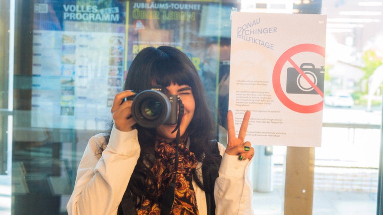 Fotografin vor einem "Fotografieren verboten"-Schild