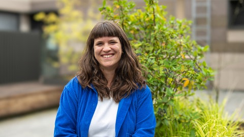 Eine Frau mit braunen Haaren lacht in die Kamera. Katharina Feißt arbeitet als Autorin und Redakteurin bei SWR Heimat in Mainz.