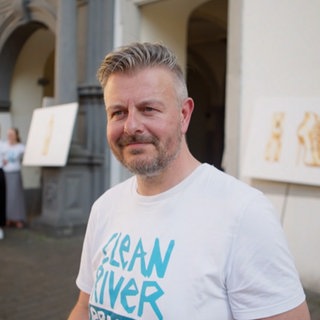 Mittelalter Mann mit grauen Haaren lächelt in die Kamera.