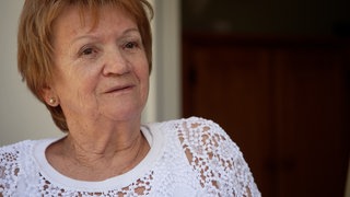 Portraitfoto einer rothaarigen Dame mit kurzen Haaren.
