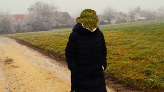  Eine Frau spaziert über ein Feld. Sie ist Lehrerin, hat einen Burnout und erzählt darüber.