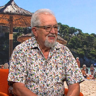 Harald, 73 Jahre alt, sitzt lächelnd als Gast in der Landesschau Baden-Württemberg. Er trägt ein buntes Hemd mit geometrischem Muster und eine Brille. Der Rentner aus Ravensburg erzählt von seiner zweiten Karriere als DJ.