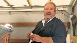 Lachender, älterer Mann auf einem Laster