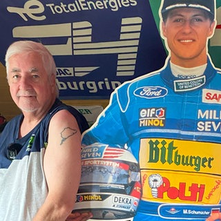 Ein Mann und eine Frau stehen neben einem Pappaufsteller von Michael Schuhmacher, haben ihr T-Shirt hochgezogen und zeigen am Oberarm ein Tattoo des Nürburgrings.