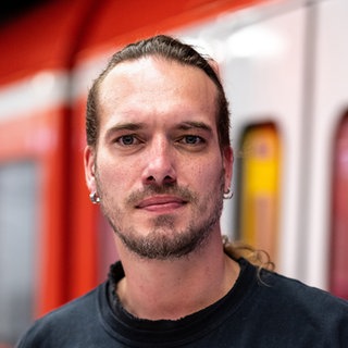 Mann steht vor S-Bahn
