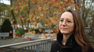 Viola - eine junge Frau mit Brille - vor der Uniklinik Freiburg