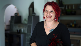 Jenny veranstaltet Dildopartys. Sie hat rote Haare und lacht in die Kamera.