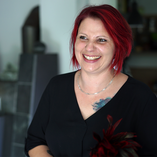 Jenny veranstaltet Dildopartys. Sie hat rote Haare und lacht in die Kamera.