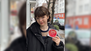 2017 verliert Clara ihre große Schwester Sophia bei einem Reitunfall. Auf dem Foto schaut Clara ernst und zeigt einen Sticker in die Kamera.