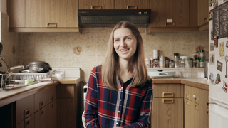 Anouk sitzt in der Küche und lacht