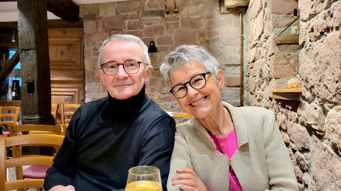 Ehepaar Friedhelm und Rose-Maria lächeln in die Kamera. Sie erzählen über ihre Tanzleidenschaft und ihren größten Erfolg: Deutscher Meister.