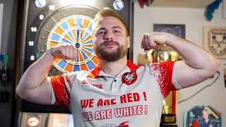 Immer mittwochs trainiert die Mannschaft „Stobach Dynamites” in ihrer Spielstätte – einer Kneipe in Öhringen. Kevin ist einer der Spieler, in einer Siegerpose zeigt er seine Oberarme.