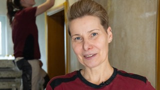 Eine Frau mit kurzen Haaren lacht in die Kamera. Malermeisterin Moni hat es sich zur Aufgabe gemacht, Frauen ins Handwerk zu bringen.