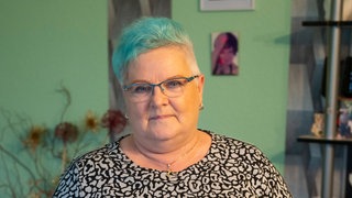 Mittelalte Frau mit türkis gefärbter Kurzhaarfrisiur