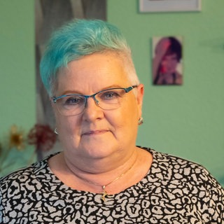 Mittelalte Frau mit türkis gefärbter Kurzhaarfrisiur